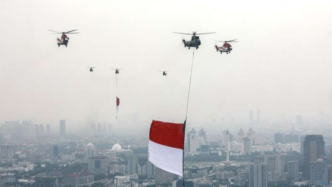 Helikopter TNI AU membawa bendera raksasa saat HUT RI ke 76 di atas Istana