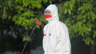 Gubernur Jawa Tengah Ganjar Pranowo berpakaian hazmat saat memimpin upacara peringatan Hari Kemerdekaan RI bersama para pasien COVID-19 di lokasi isolasi terpusat di Asrama Haji Donohudan, Boyolali, Selasa, 17 Agustus 2021.