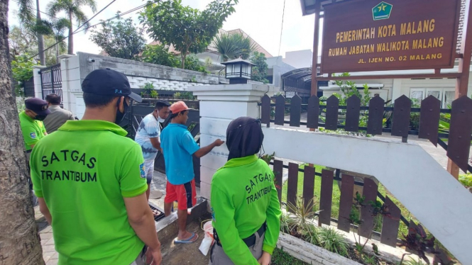 Petugas Satpol PP bersihkan coretan vandalisme di Rumah Dinas Wali Kota Malang.