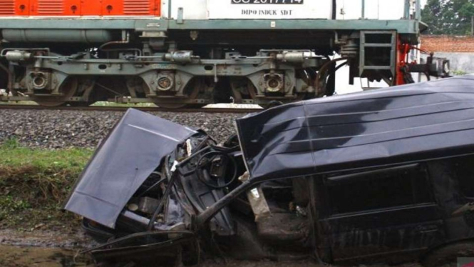 Dokumentasi. Sebuah kereta api melintas di depan bangkai mobil minibus bernopol N 1447 CP yang ringsek usai ditabrak kereta api di perlintasan tanpa palang pintu di Sonotengah, Malang, Jawa Timur, Rabu, 27 Oktober 2021.