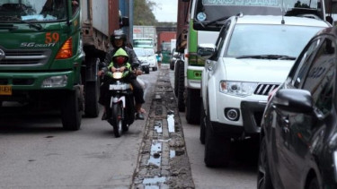 Naik Motor di Dekat Truk.