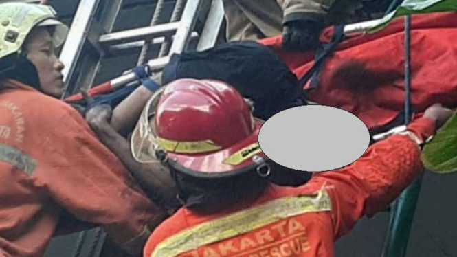 Petugas saat mengevakuasi korban kebakaran di Gedung Cyber, Jakarta Selatan.