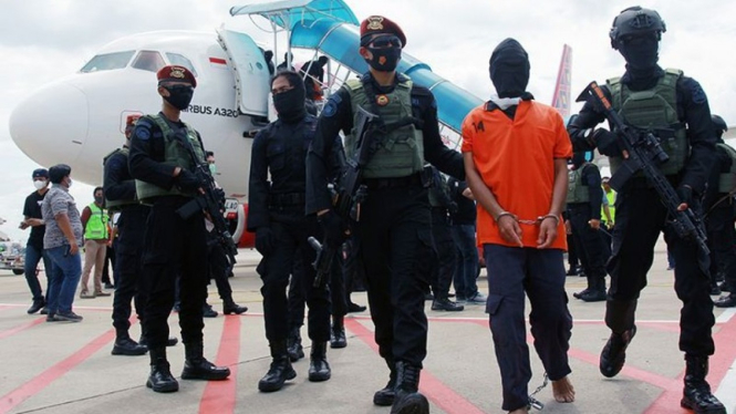 Densus 88 membawa terduga teroris Taufik Bulaga alias Upik Lawanga.
