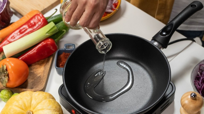 Ilustrasi memasak dengan minyak goreng.