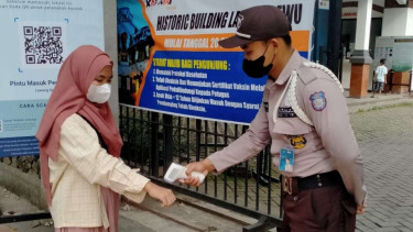 Petugas sedang memeriksa suhu tubuh pengunjung Lawang Sewu.