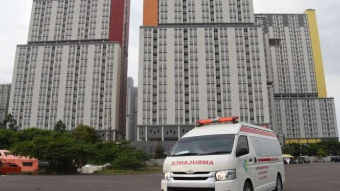 Mobil ambulans berjalan keluar dari RSDC Wisma Atlet Kemayoran.