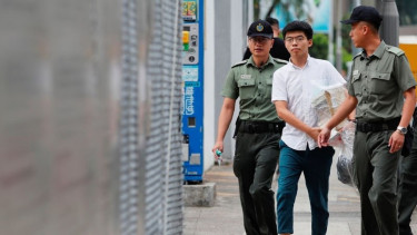 Mantan pemimpin mahasiswa Joshua Wong dikawal petugas keamanan.