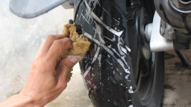Membersihkan ban motor.