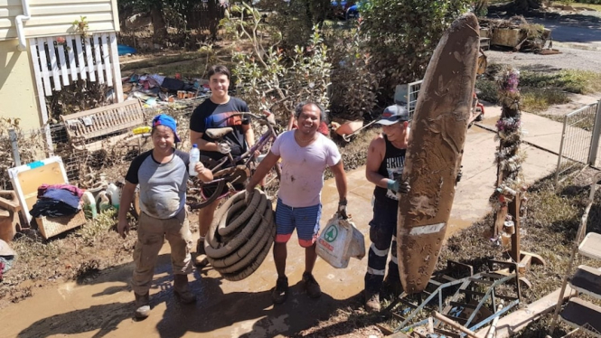 Warga asal Indonesia di Kota Lismore, Yoyok Hendrix (kedua dari kanan) membersihkan puing-puing akibat banjir di rumahnya dibantu sejumlah rekan-rekannya, Rabu (2/03). (Supplied: Katie Suhartoyo)