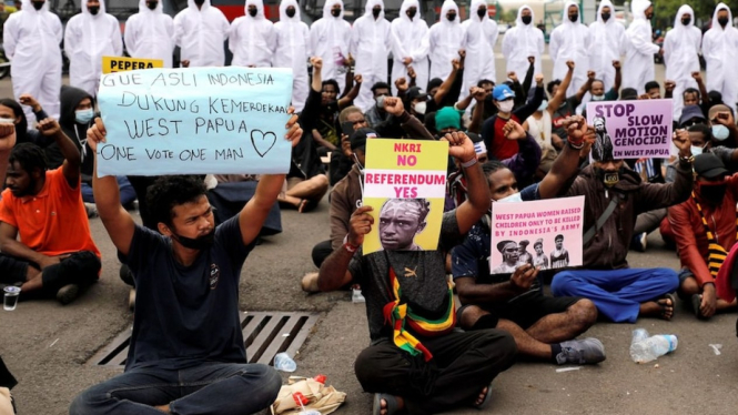 Polisi mengenakan APD menjaga unjuk rasa warga Papua dan aktivis lainnya di dekat Monas di Jakarta 1 Desember 2021. (REUTERS/Willy Kurniawan)