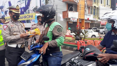 Polisi bagi-bagi minyak goreng gratis.