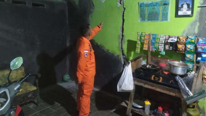 Petugas BPBD Tegal menunjukkan retakan di sebuah rumah.