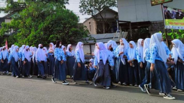 Siswa sekolah memadati pinggir jalan untuk menyambut rombongan yang membawa jenazah putra sulung Gubernur Jawa Barat Ridwan Kamil, Emmeril Kahn Mumtadz alias Eril, menuju ke lokasi permakaman di Kecamatan Cimaung, Kabupaten Bogor, Jawa Barat, Senin, 13 Ju