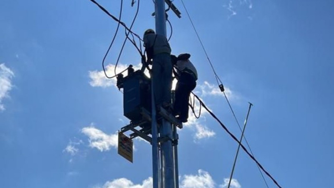 Petugas PLN saat mengalirkan listrik.