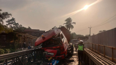 Truk tangki Pertamina tabrak pembatas jalan.