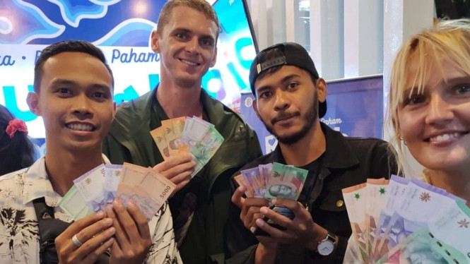 Bule di Bali antusias tukar uang ke rupiah baru.
