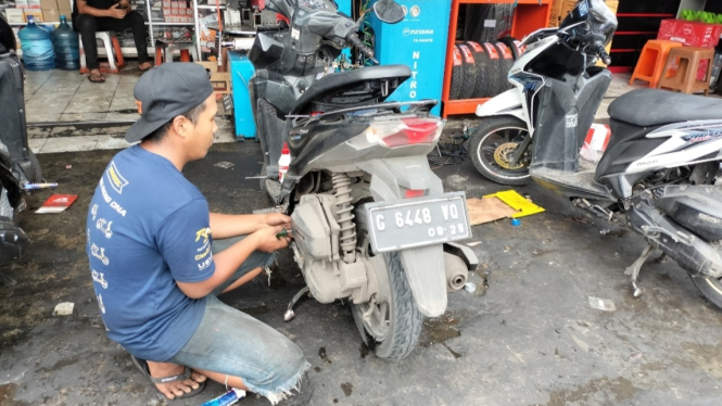 Montir motor sedang memperbaiki mesin