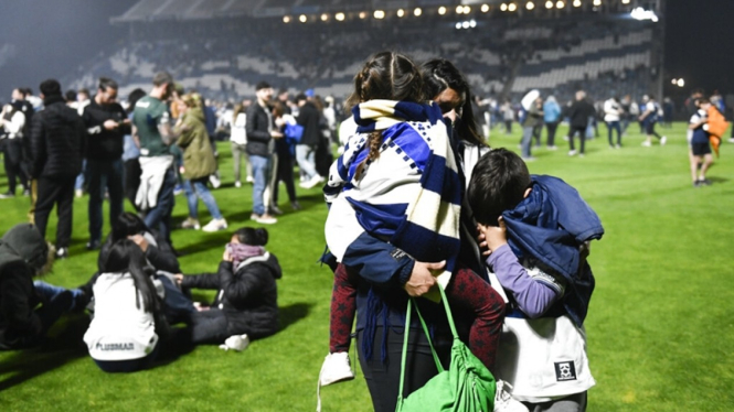 Penonton saat merasakan dampak gas air mata dalam laga Gimnasia vs Boca Juniors