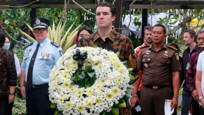 Asisten Menteri Luar Negeri Australia Tim Watts (tengah) membawa karangan bunga dalam upacara peringatan 20 tahun bom Bali, 20 Oktober 2022.