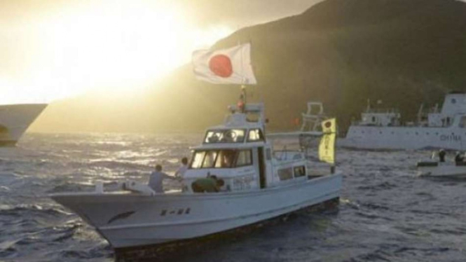Kapal pengawas laut China Haijian No.51 berlayar di dekat kapal-kapal Penjaga Pantai Jepang (kanan dan kiri) dan sebuah kapal nelayan Jepang di perairan dekat Pulau Uotsuri, Senin, 1 Juli 2022.