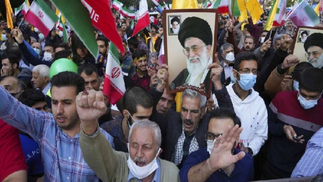 Demonstran mengangkat poster Pemimpin Tertinggi Iran Ayatollah Ali Khamenei 