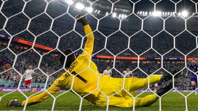 Kiper Polandia  Wojciech Szczesny menggagalkan penalti Lionel Messi