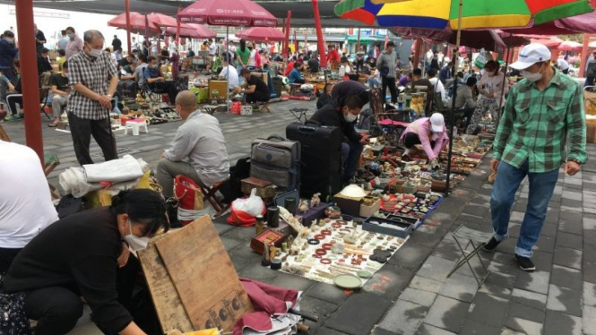 Para pedagang di pasar barang antik Panjiayuan, Beijing, China, Minggu (12/6/2022), mulai beraktivitas kembali setelah ditutup total akibat ditemukan klaster baru COVID-19 pada 22 April 2022.