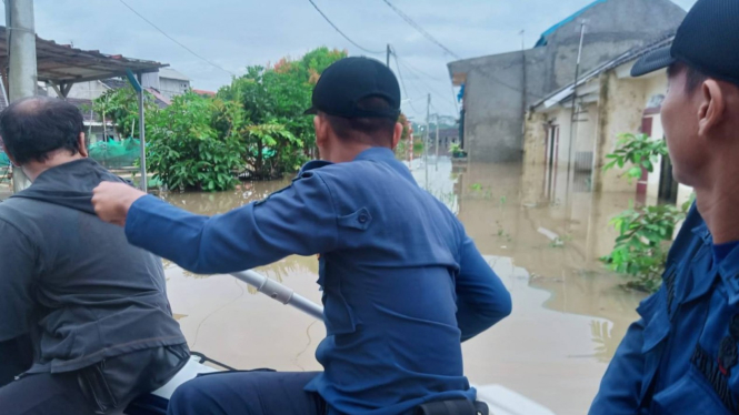 Petugas saat mengecek lokasi banjir dengan perahu karet.
