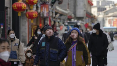 Orang-orang memakai masker di Beijing, China.