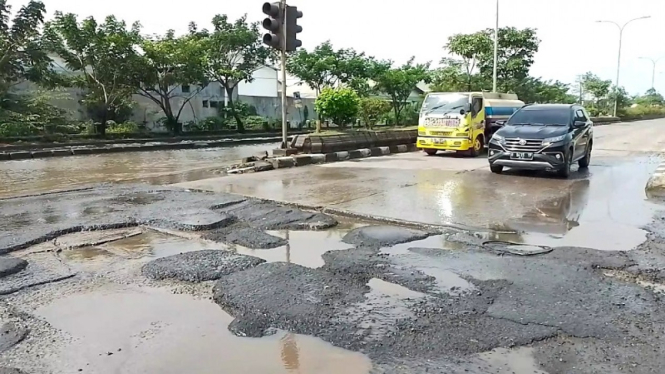 Jalan berlubang di Jalan Kaligawe yang baru surut terendam Banjir Semarang