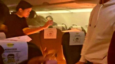 Kru pesawat Scoot Airlines memadamkan api dari power bank yang meledak
