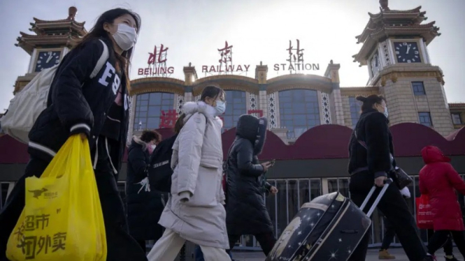 Warga Beijing memakai masker untuk melindungi diri dari COVID-19.