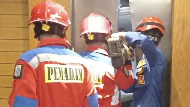 Petugas Damkar mengevakuasi warga yang terjebak di lift macet restoran