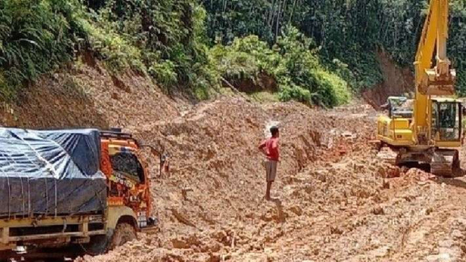 Sebanyak 150 truk dan kendaraan double cabin terjebak di jalan trans-Papua ruas Jayapura-Wamena. Tampak alat berat sedang berupaya membantu mengeluarkan truk.