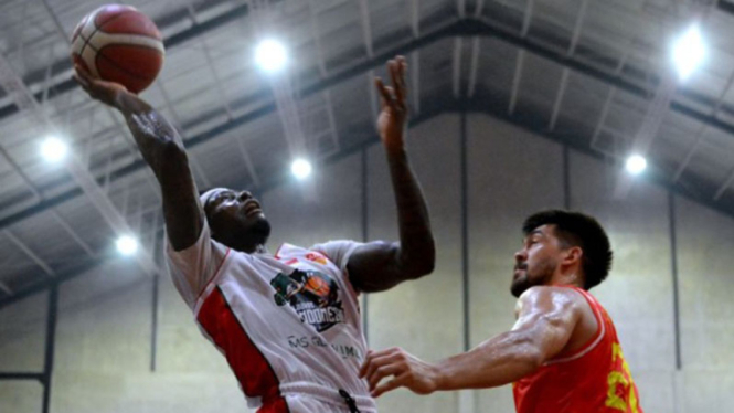 Aksi pebasket Louvre Surabaya, Michael Ayodele Kolawole (kiri)