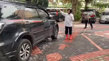 Menteri Sosial Tri Rismaharini mencuci mobil.