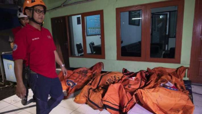 Seorang petugas berjalan di dekat kantong berisi jenazah korban kebakaran pipa Pertamina Plumpang di Jakarta, Jumat malam, 3 Maret 2023.