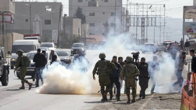 Tentara Israel menyemprotkan gas air mata ke warga Palestina di Kota Hawara, di Tepi Barat.