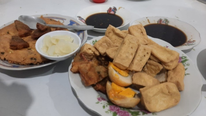Sepaket porsi tahu pong plus gimbal dan telur serta kuah petis dan acar lobak.