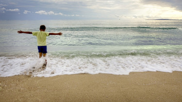anak laki-laki main di pantai, berjemur