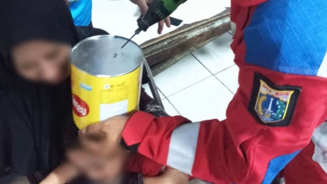 Kepala Bocah masuk ke kaleng biskuit
