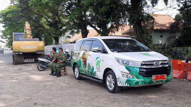 Dua petugas Linmas menjaga mobil dinas Wali Kota Solo Gibran Rakabuming Raka yang diparkirkan di di sebelah barat proyek pelebaran Viaduk Gilingan, Banjarsari, Solo, Jawa Tengah, Rabu sore, 26 April 2023.