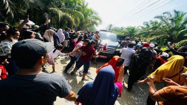 Mobil RI 1 yang melintasi jalan berkubang di Labura Sumut dikerubuti warga
