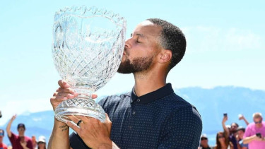 Stephen Curry mengangkat trofi dalam turnamen golf