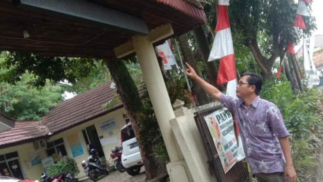 Lurah Kemuning, M Yusuf Ermidi, menunjukkan plang running text