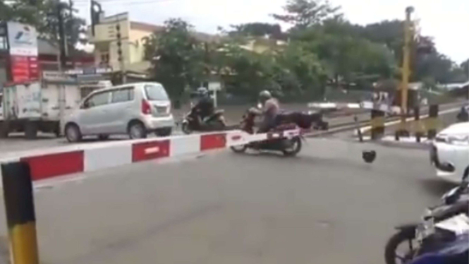 Detik-detik Pengendara Motor Nerobos Palang Kereta Api