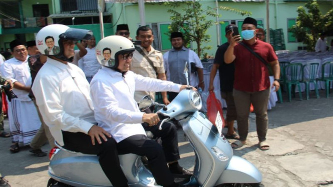 Anies dan Cak Imin saat mengendarai Vespa di Ponpes Mambaul Maarif.