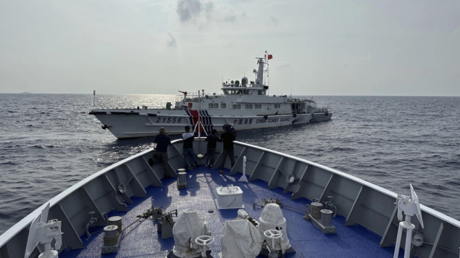 Sebuah kapal penjaga pantai Tiongkok berada dekat dengan kapal patroli Filipina di Laut Cina Selatan.