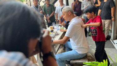 Bakal calon presiden Ganjar Pranowo, saat bersama sang istri Siti Atikoh dan anaknya Muhammad Zinedine Alam Ganjar, dipijat oleh seorang anak kala mereka makan siang bersama di satu restoran di Jakarta Selatan, Sabtu, 21 Oktober 2023.