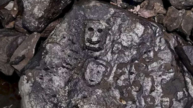 Wajah misterius muncul di bebatuan ketika air sungai lagi surut.